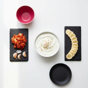 Fermented and prebiotic foods including yogurt, kimchi, garlic, and bananas that support gut-brain health